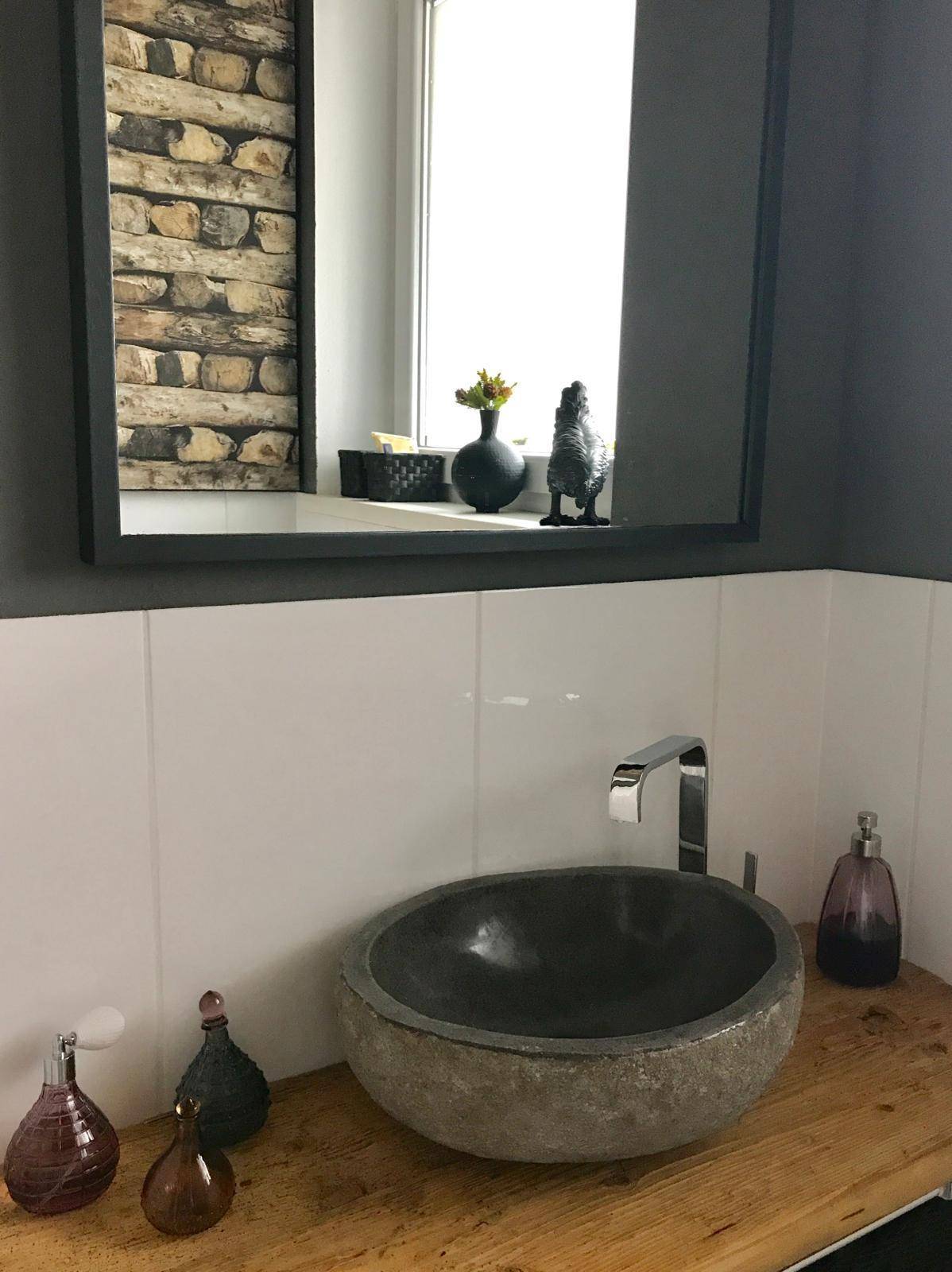 Stilvolles Gäste-WC mit Natursteinwaschbecken und Holzwaschtischplatte.