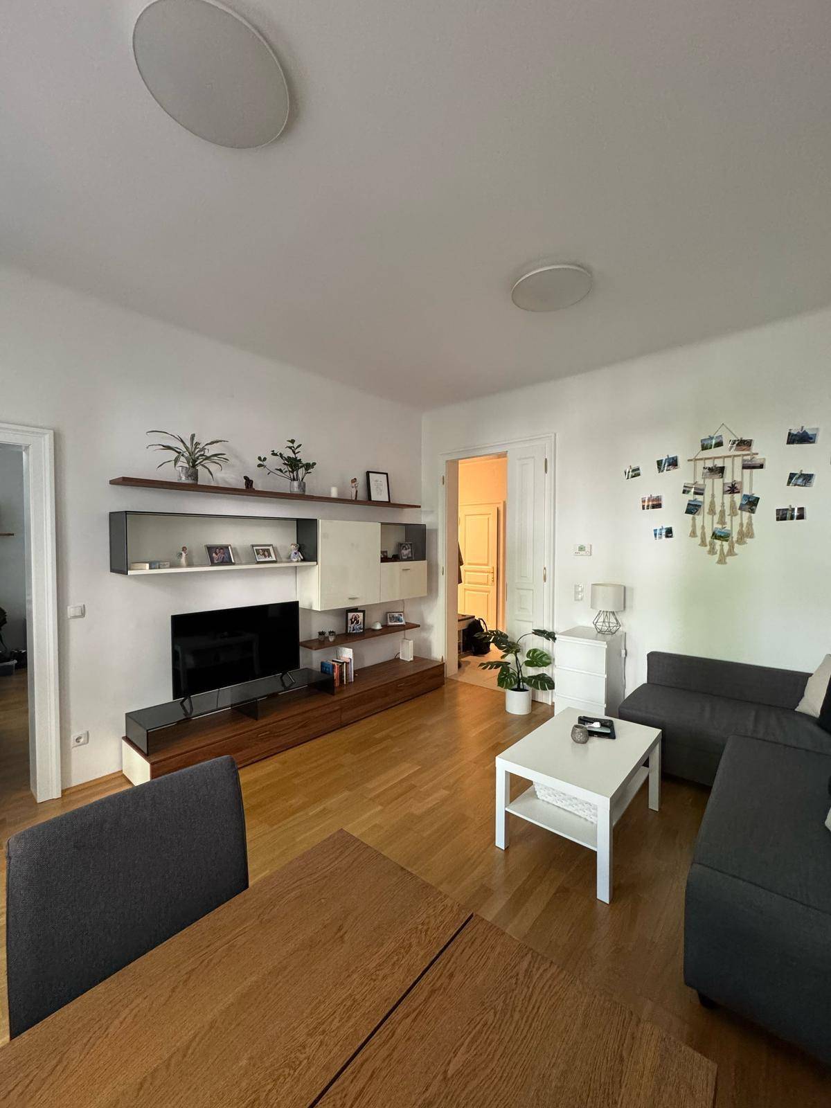 Gemütliches Wohnzimmer mit Ecksofa, Couchtisch und Blick auf den Essbereich.