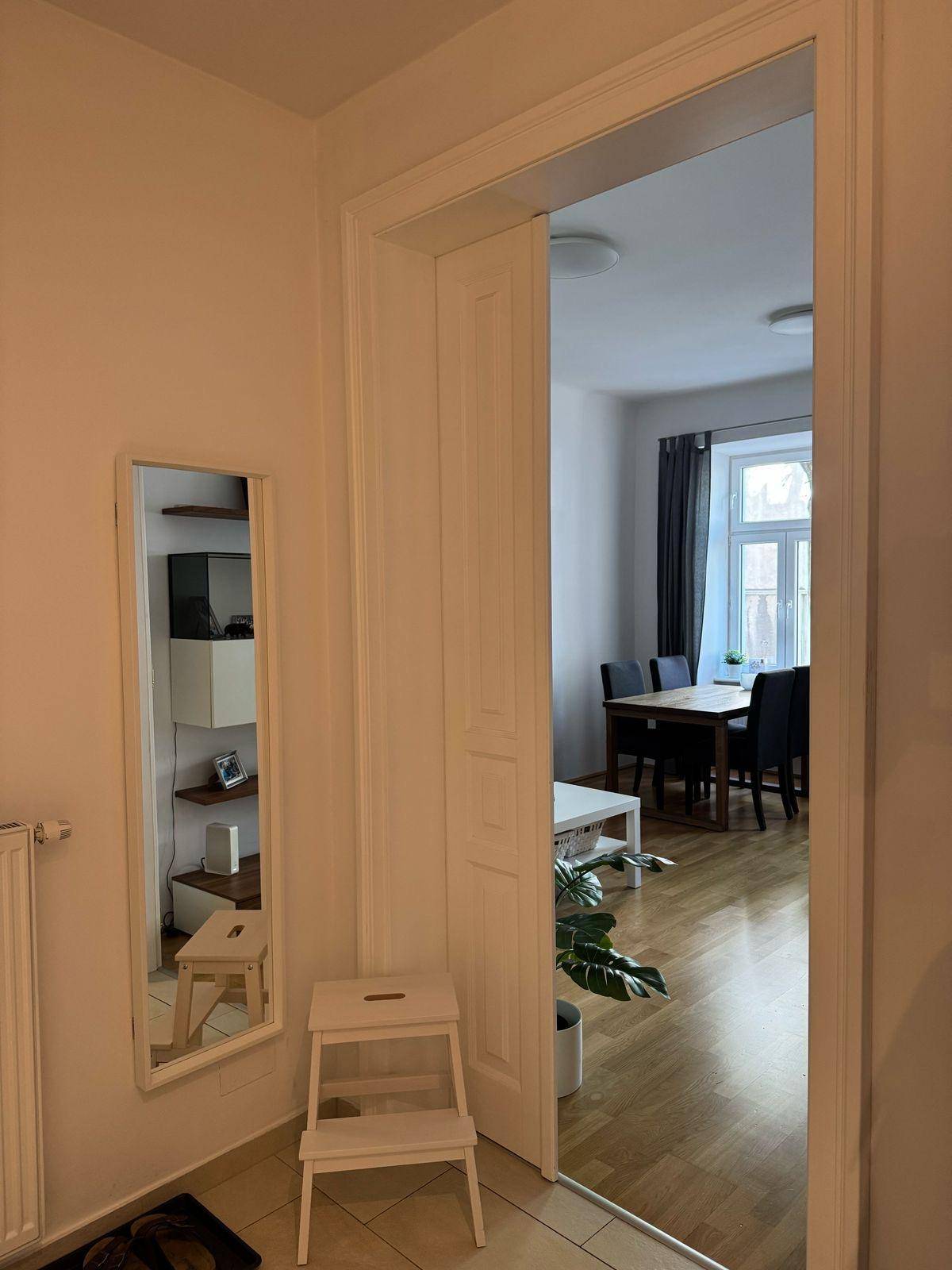 Heller Flur mit Spiegel und Blick in den offenen Wohn-Essbereich.