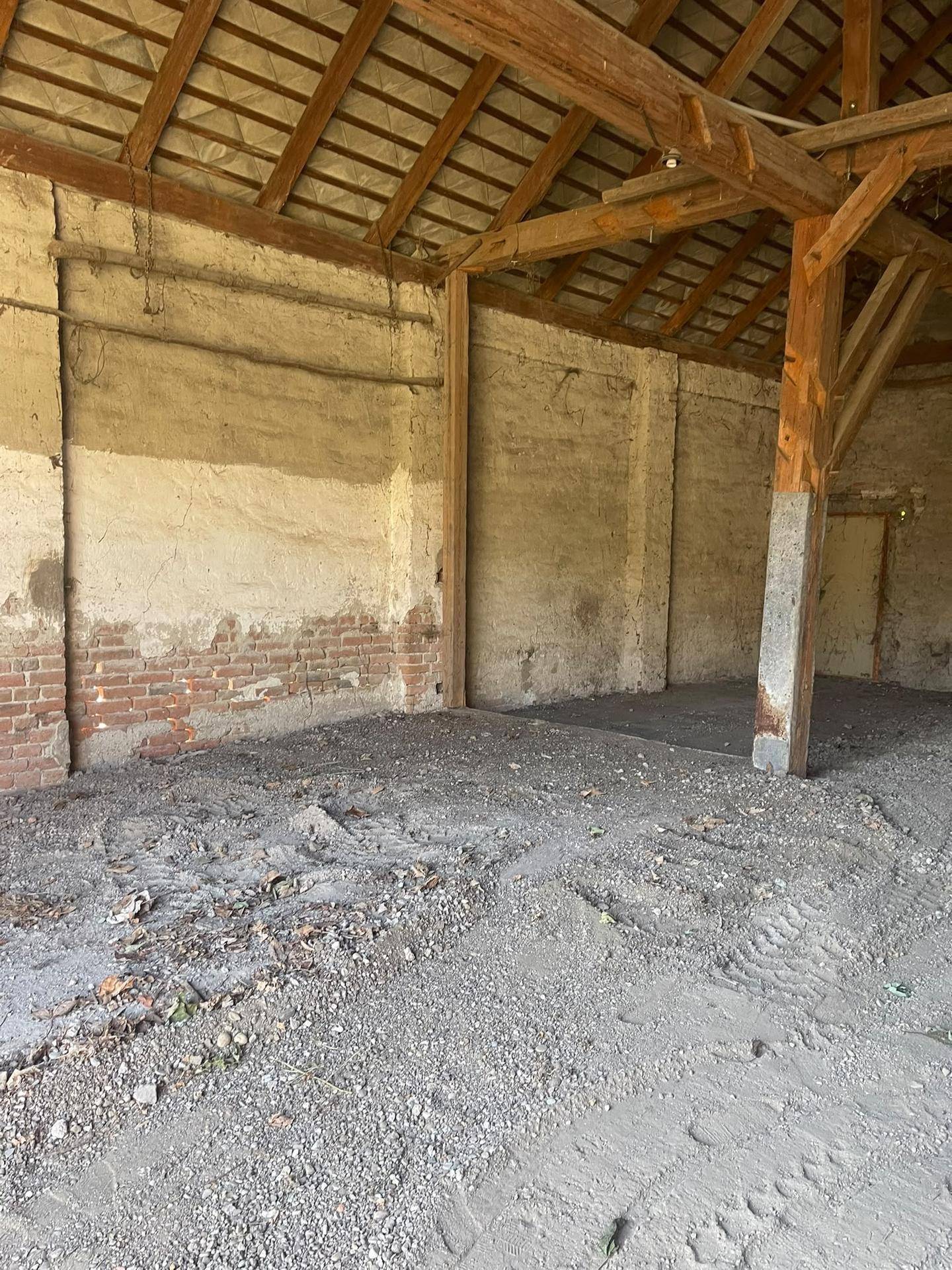Rustikaler Innenraum mit freiliegenden Holzbalken und unverputzten Wänden, bietet viel Potenzial.