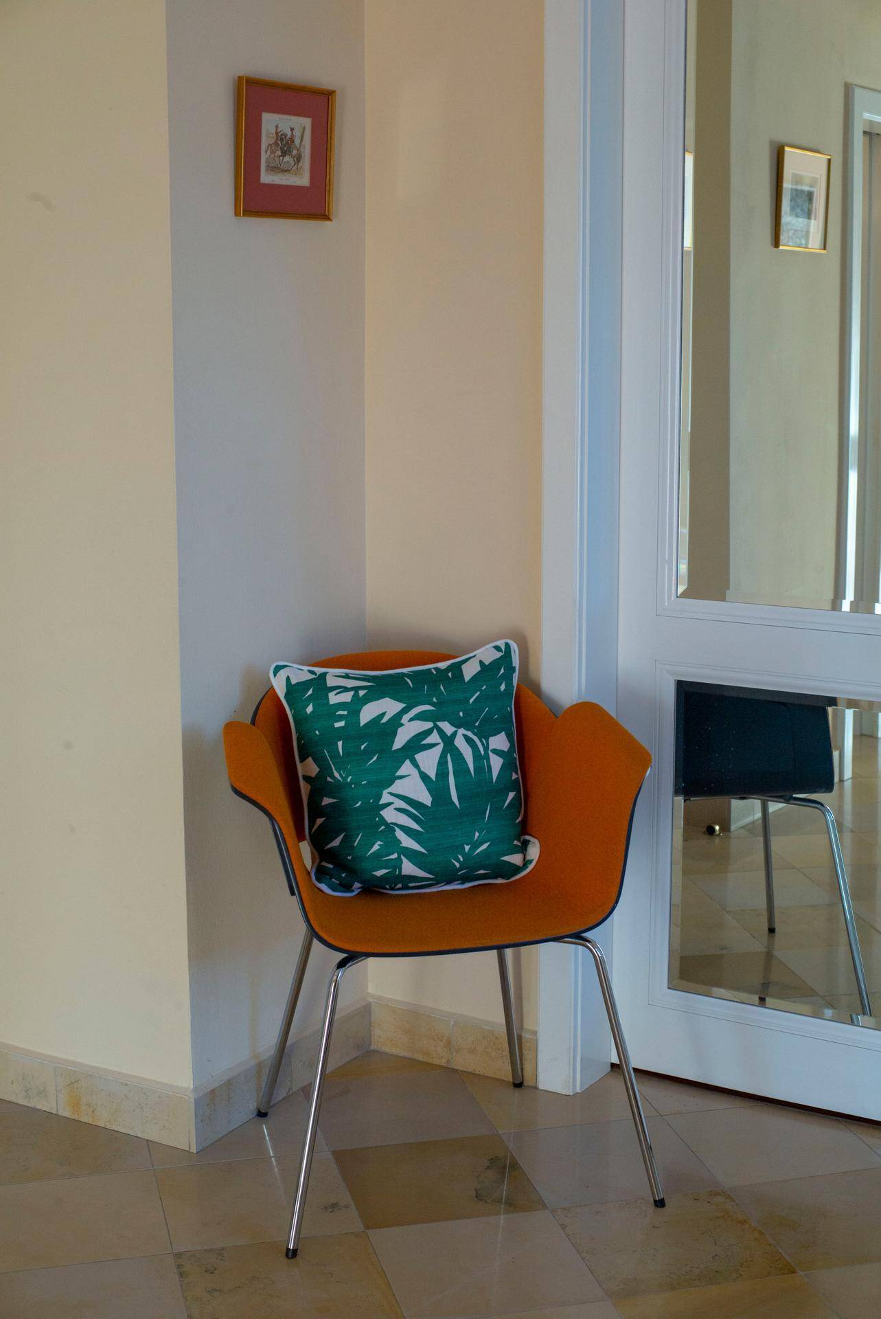 Moderne orangefarbene Sitzgelegenheit mit Zierkissen im Eingangsbereich.