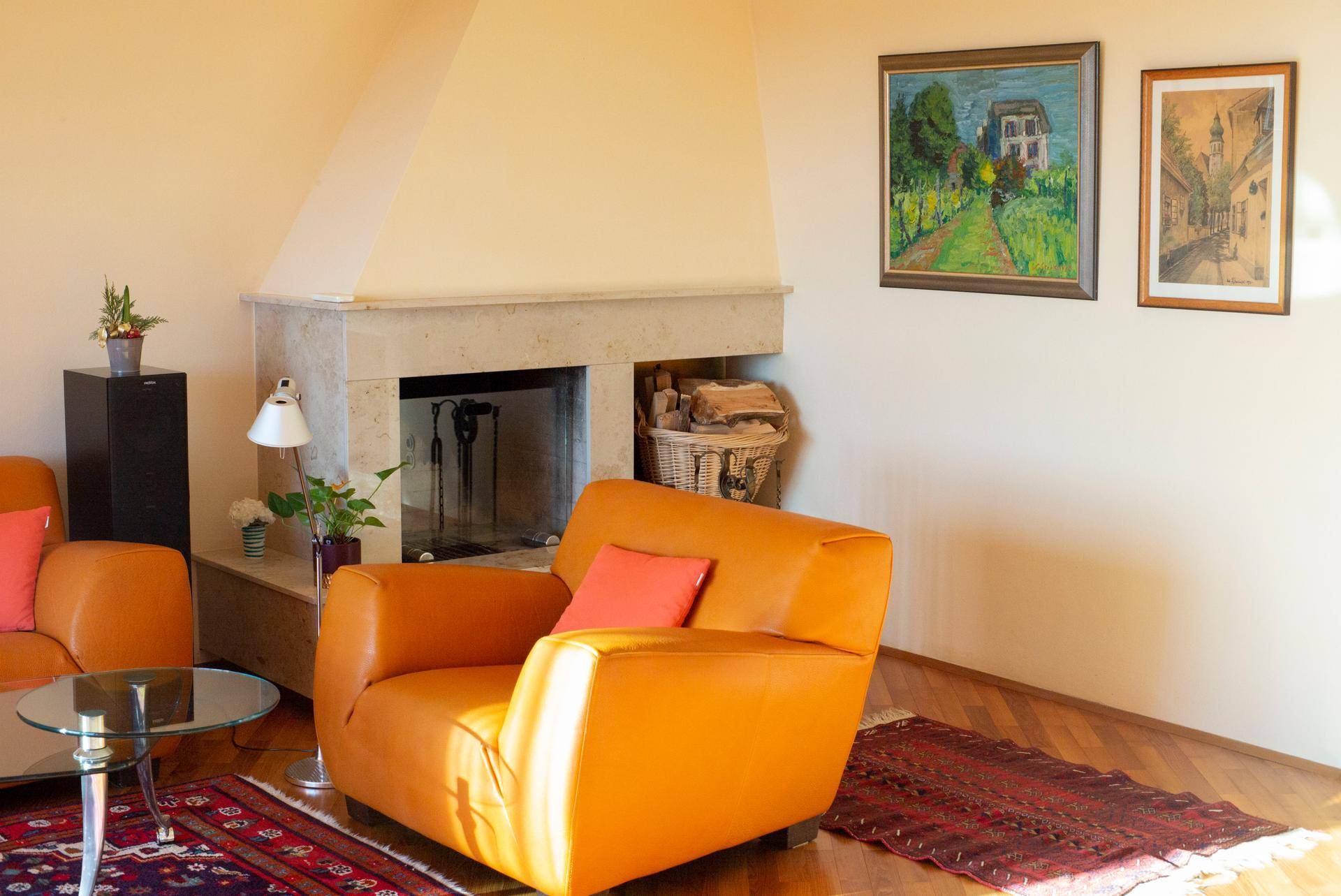 Gemütliches Wohnzimmer mit Kamin, Ledersessel und Holzboden, ideal zum Entspannen.