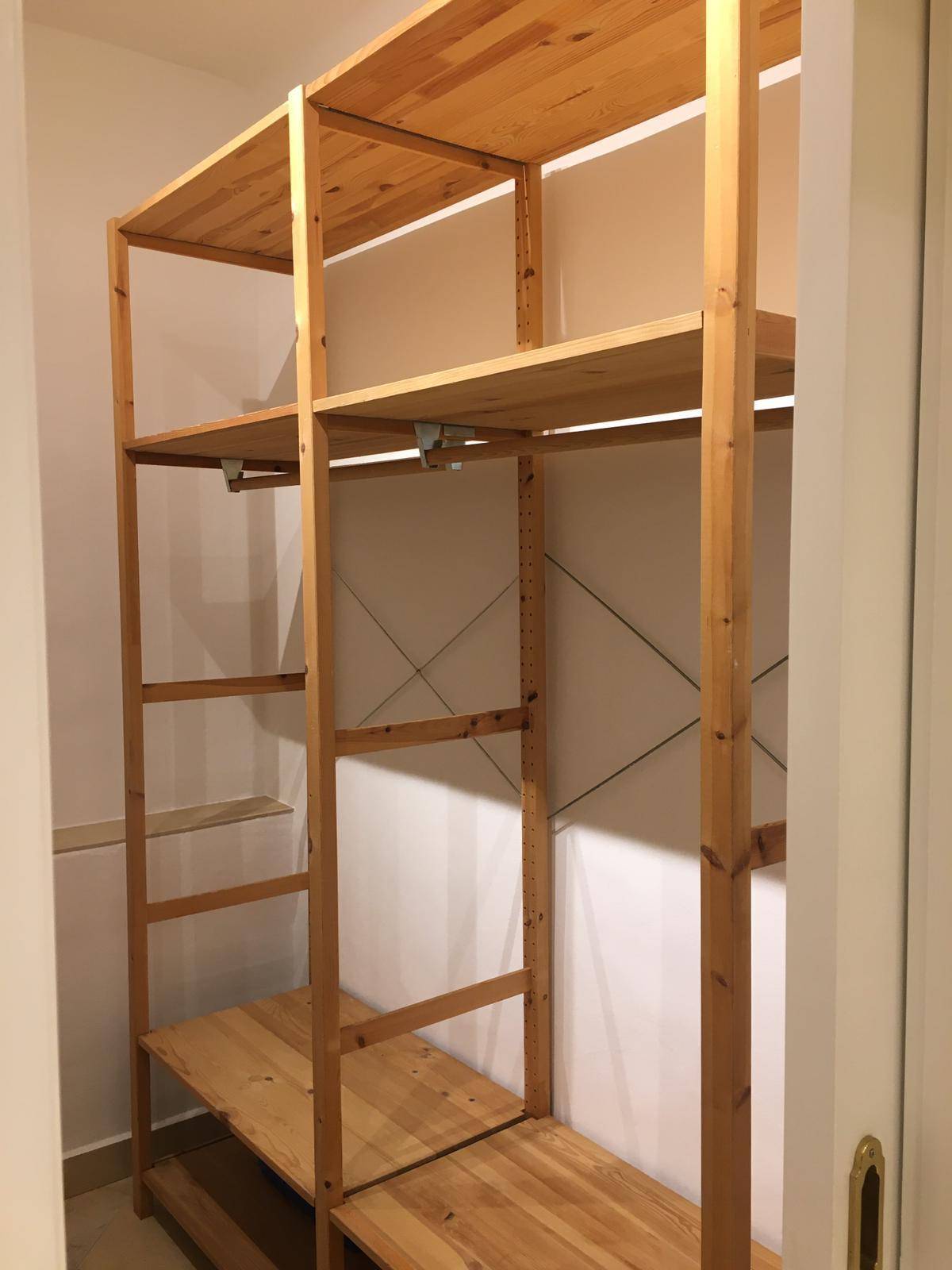 Helle Holzregale in einem Abstellraum, ideal für zusätzlichen Stauraum.