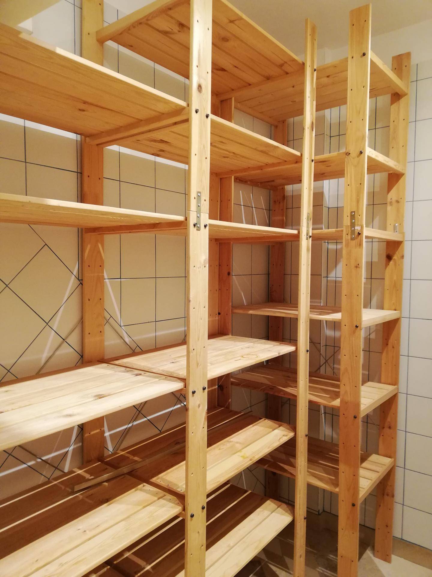 Geräumiger Abstellraum mit vielen Holzregalen für Lagerzwecke.