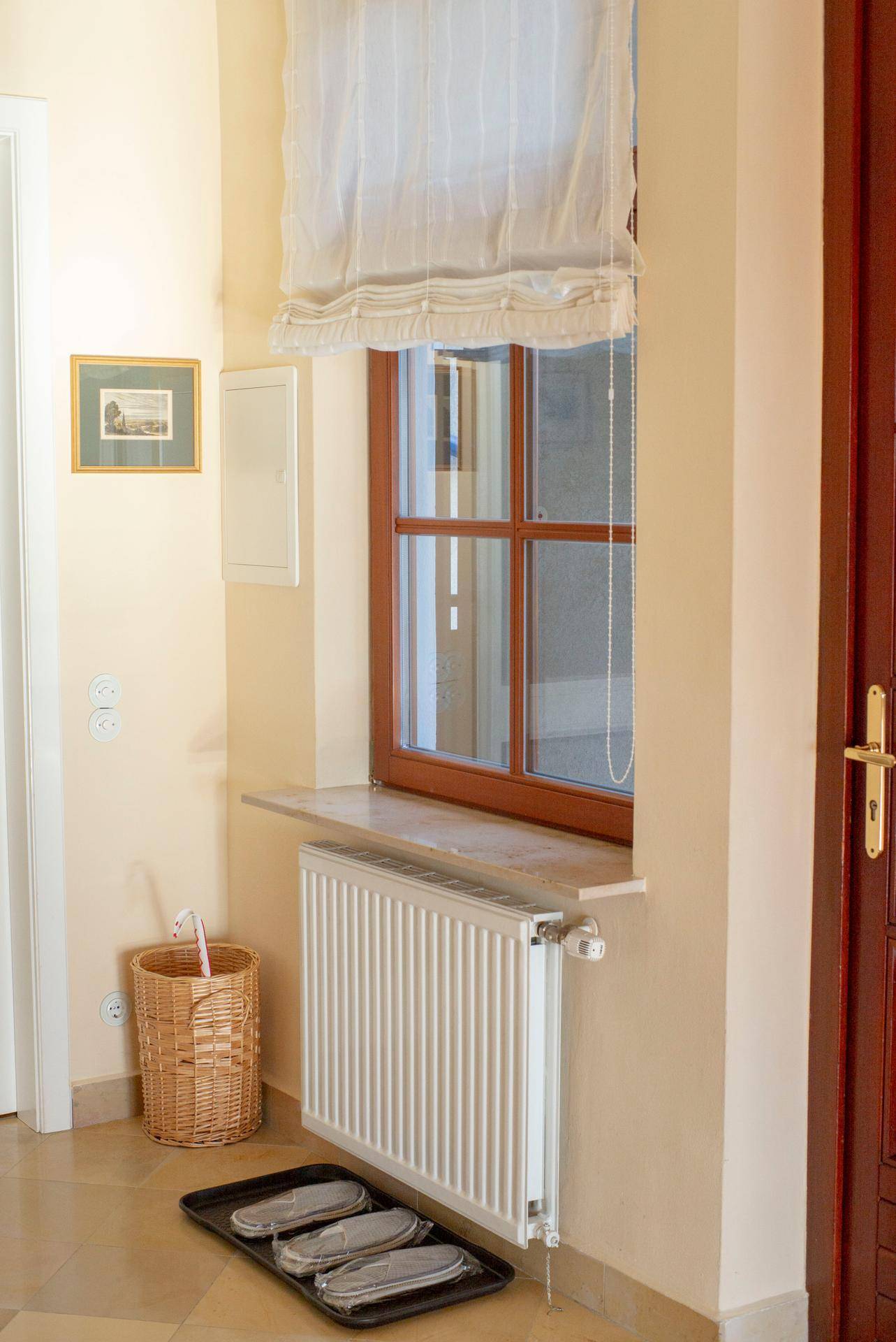 Detailansicht eines Fensters im Flur mit Heizkörper und Ablagefläche.