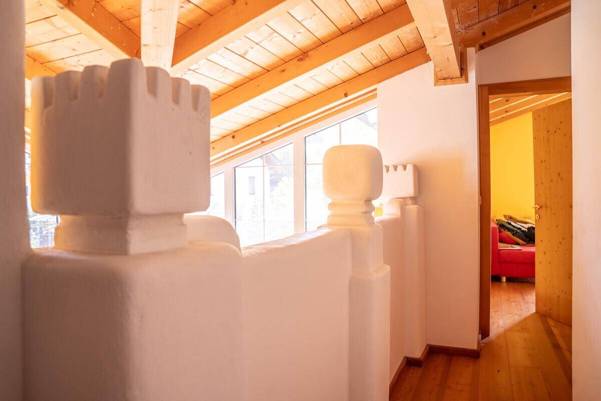 Heller Flur im Dachgeschoss mit Holzbalkendecke und Blick in ein weiteres Zimmer.