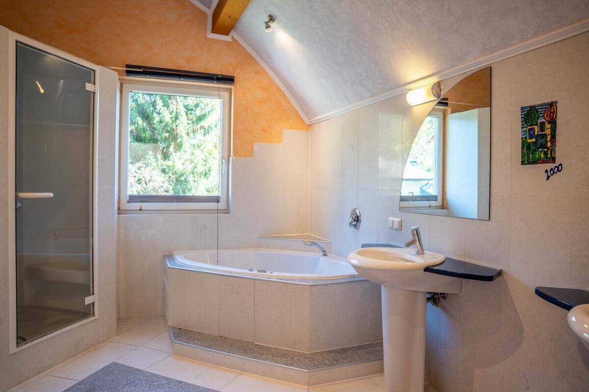 Geräumiges Badezimmer mit Eckbadewanne, separater Dusche und Fenster.