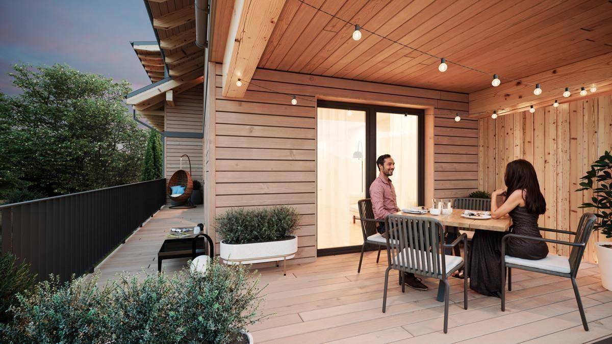 Gemütliche Holzterrasse mit Esstisch, Sitzgelegenheiten und stimmungsvoller Beleuchtung für entspannte Abende.