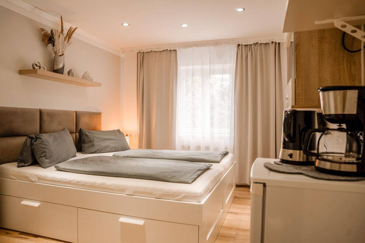 Gemütliches Schlafzimmer mit Doppelbett, Nachttischen und Kaffeemaschine für einen angenehmen Aufenthalt.
