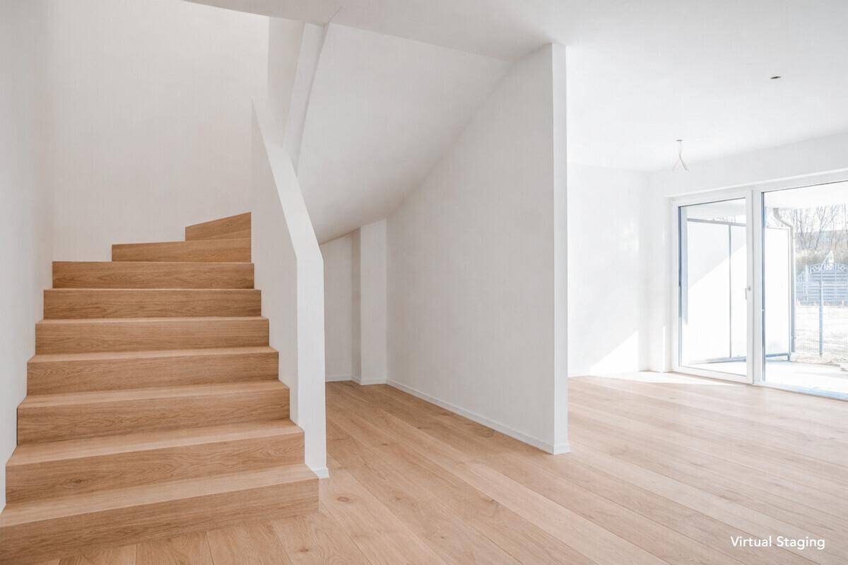 Heller Eingangsbereich mit moderner Holztreppe und Parkettboden, führt zu großen Fenstern.