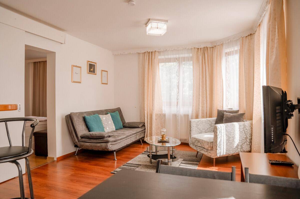 Gemütlicher Wohnbereich mit Sofa, Sessel und Esstisch, ideal für entspannte Abende.