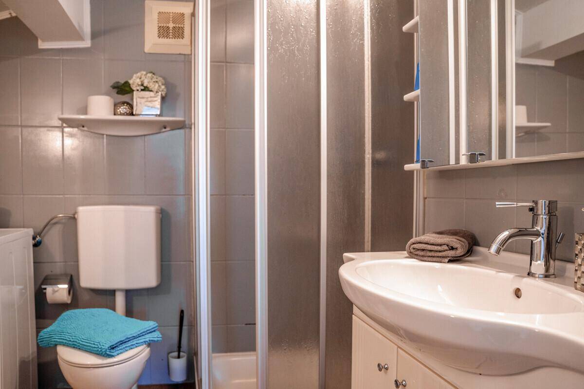 Funktionales Badezimmer mit Dusche, WC und Waschbecken, ausgestattet für den täglichen Bedarf.