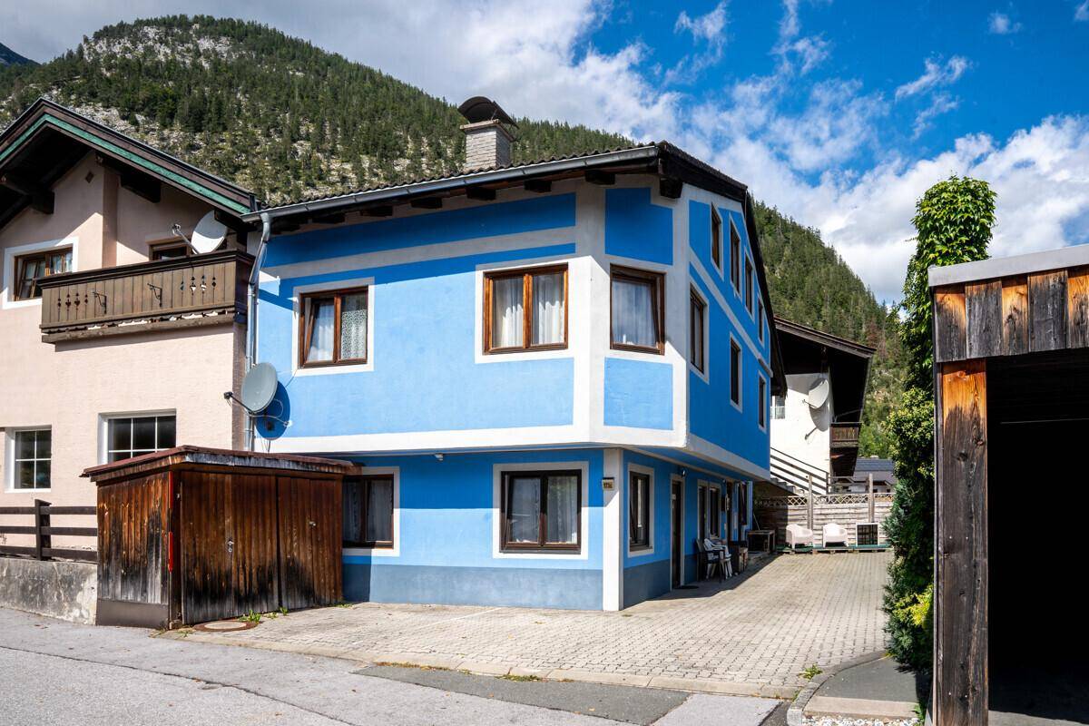 Charmantes Gebäude mit leuchtend blauer Fassade und traditionellen Holzelementen in ländlicher Umgebung.