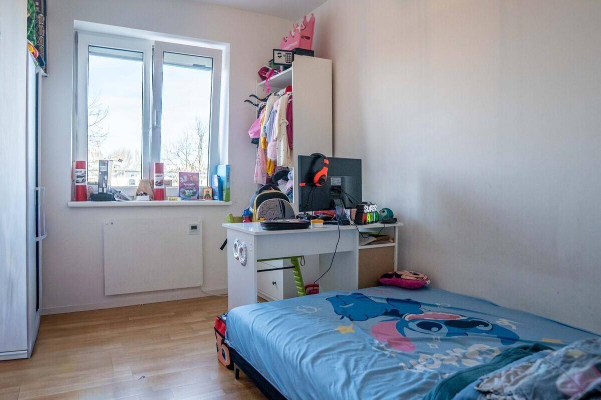 Kinderzimmer oder Gästezimmer mit Schreibtisch, Bett und Fenster mit Blick ins Grüne.