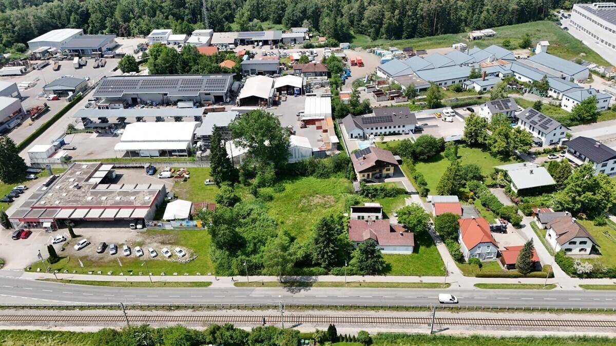 Weitläufige Luftansicht einer Mischzone aus Wohn- und Gewerbegebäuden umgeben von Natur und Feldern.