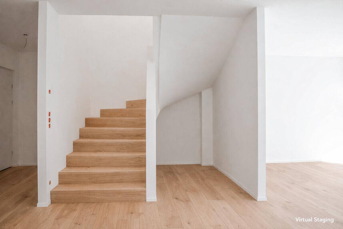 Heller Flurbereich mit eleganter Holztreppe und Parkettboden, modern und einladend gestaltet.