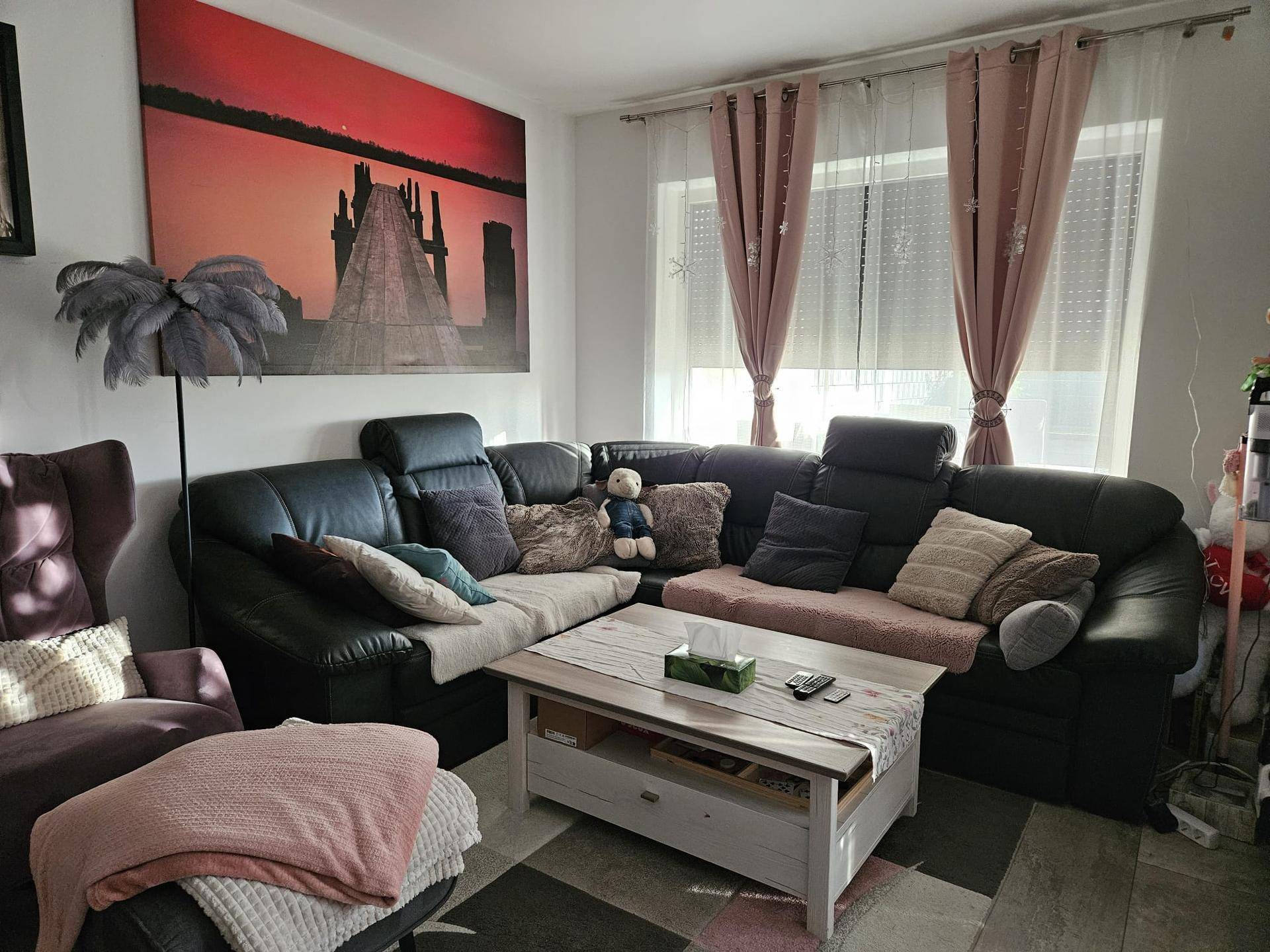 Gemütliches Wohnzimmer mit großer Eckcouch, Couchtisch und Fensterblick.