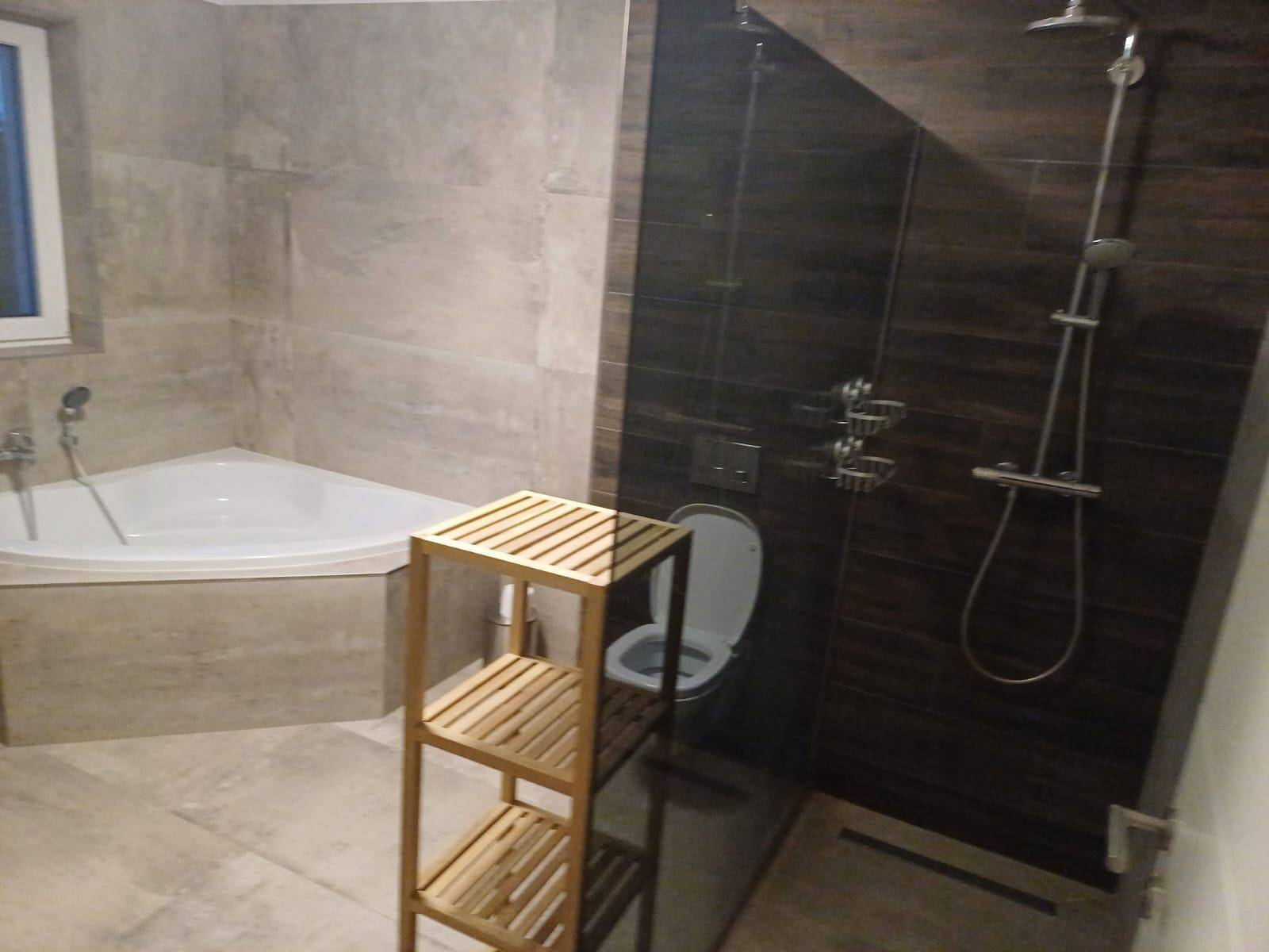 Modernes Badezimmer mit Eckbadewanne, Dusche und Wand-WC.