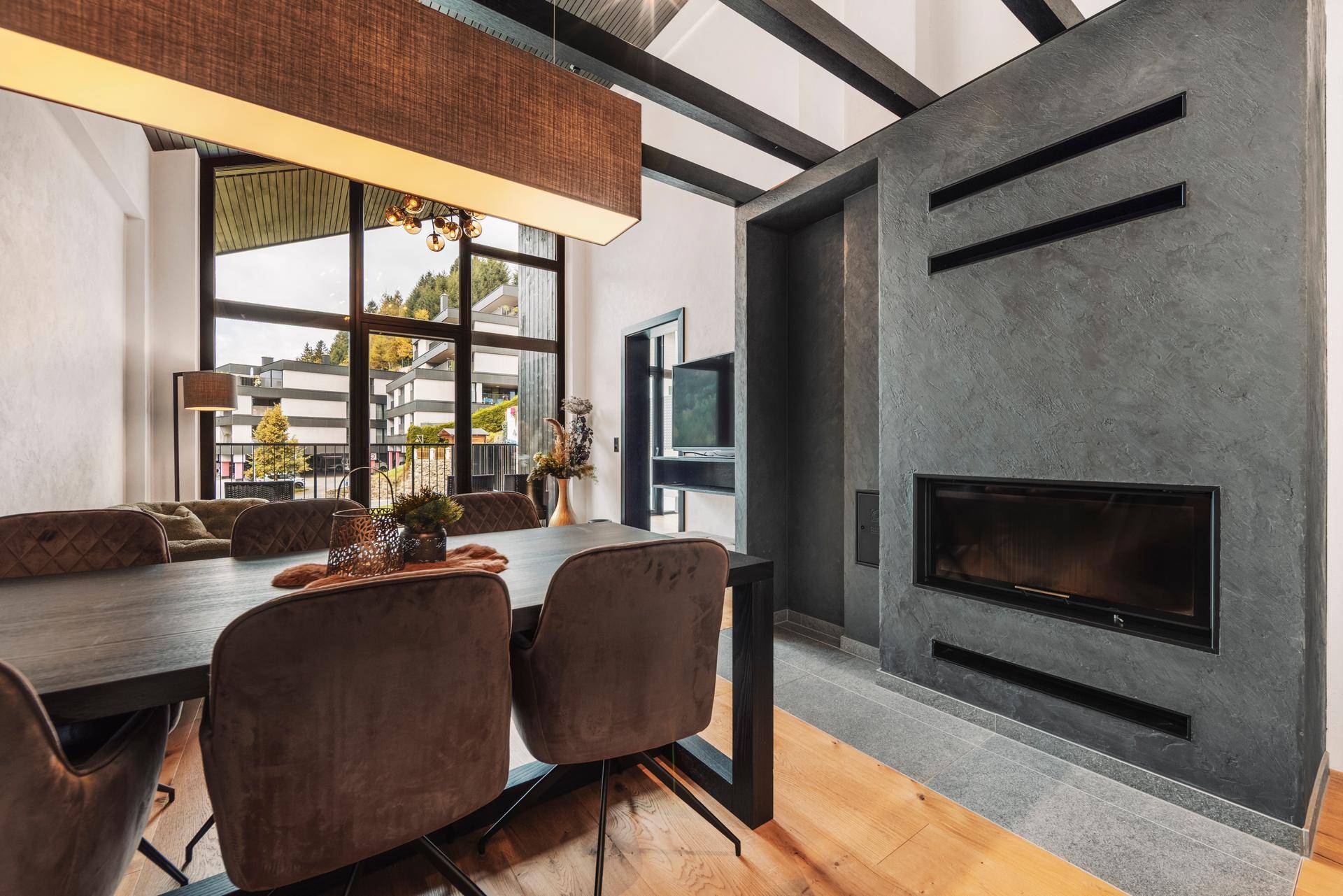 Eleganter Essbereich mit großem Tisch, Kamin und weitem Blick durch die Fenster.