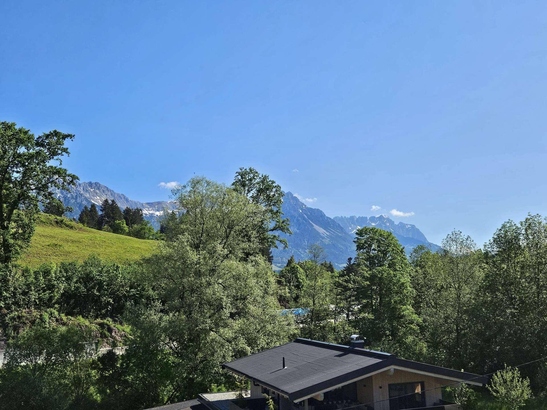 Weitläufiger Panoramablick auf die majestätischen Berge und die umliegende grüne Landschaft.