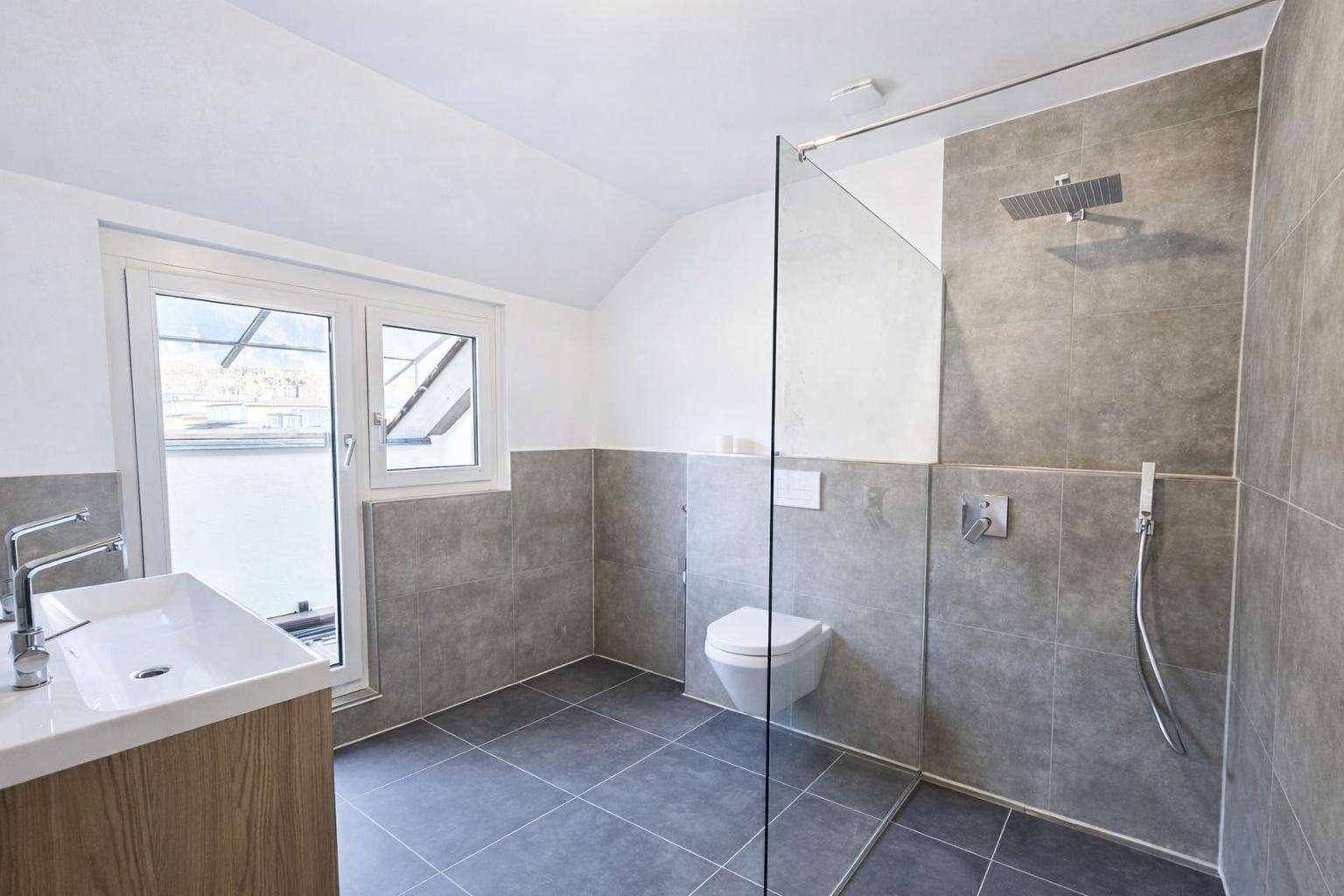 Modernes Badezimmer mit begehbarer Dusche, Wand-WC und Fenster.