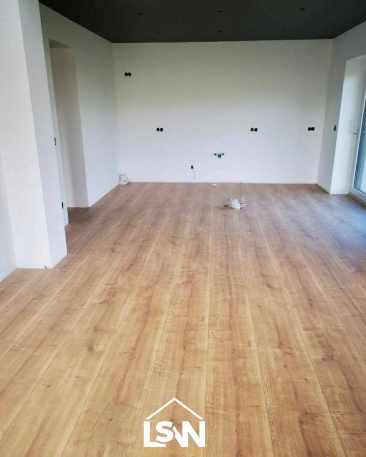 Geräumiger Innenraum mit Holzboden und dunkler Decke, ideal für die individuelle Gestaltung vor dem Erstbezug.