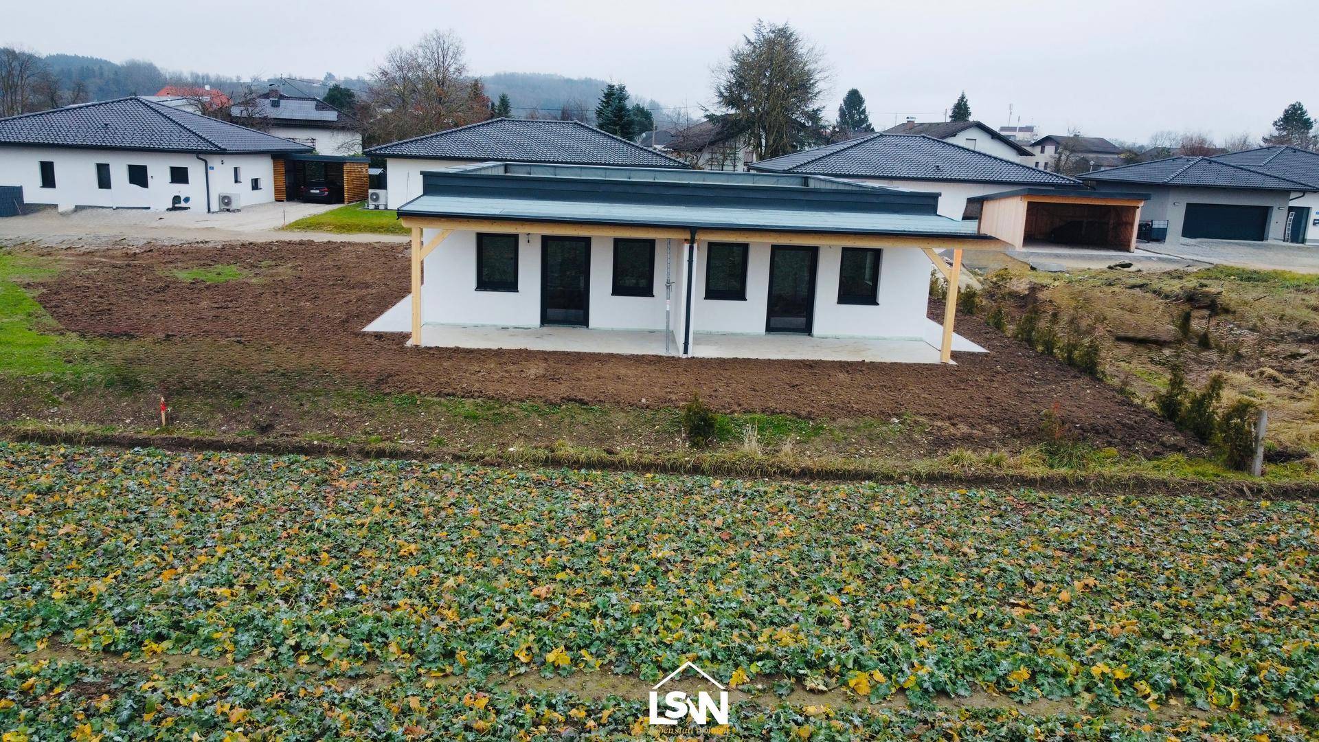 Modernes Einfamilienhaus mit großer überdachter Terrasse und Blick auf die umliegende Bebauung.