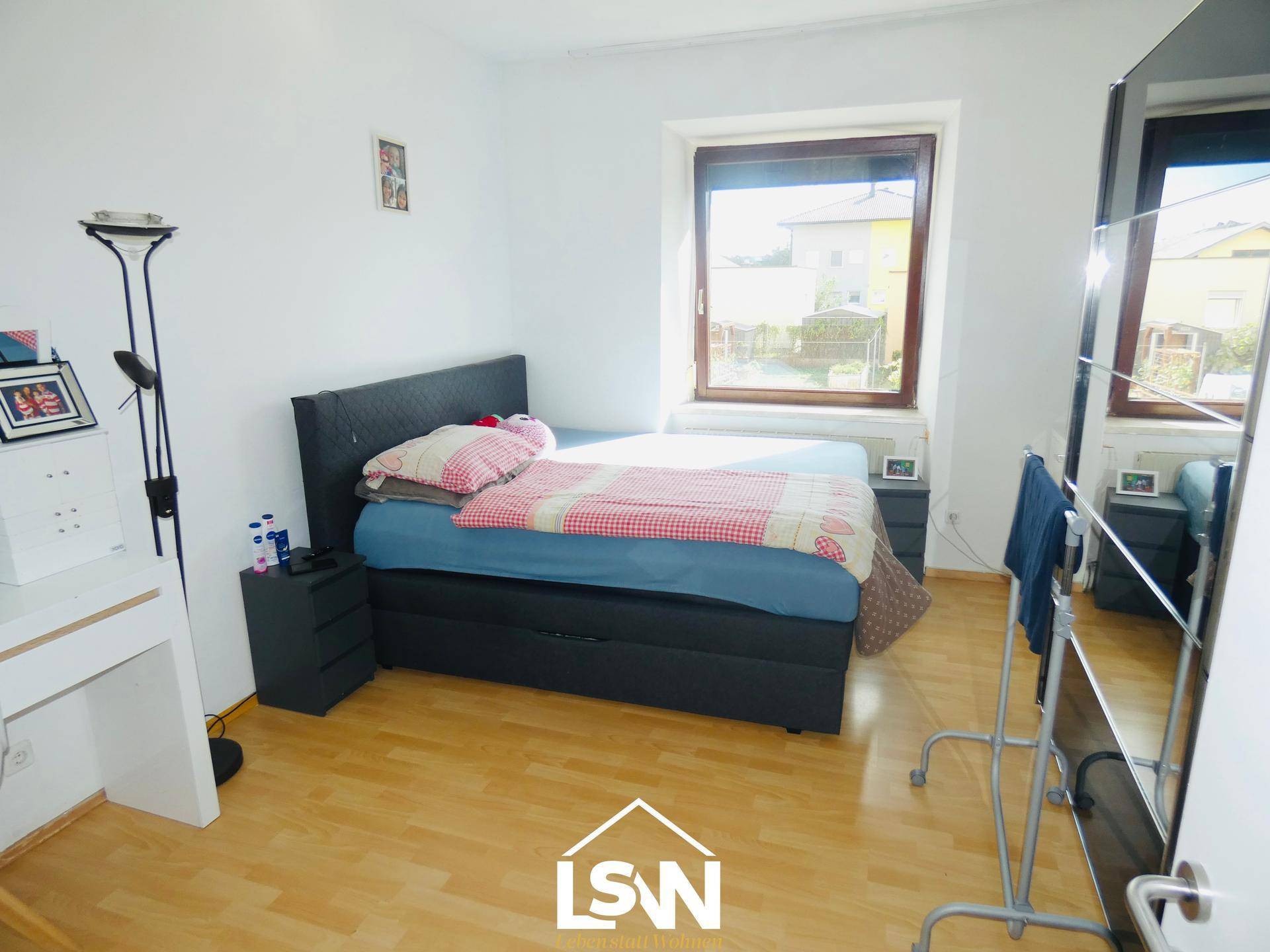 Gemütliches Schlafzimmer mit Doppelbett, Schreibtisch und großem Spiegel.