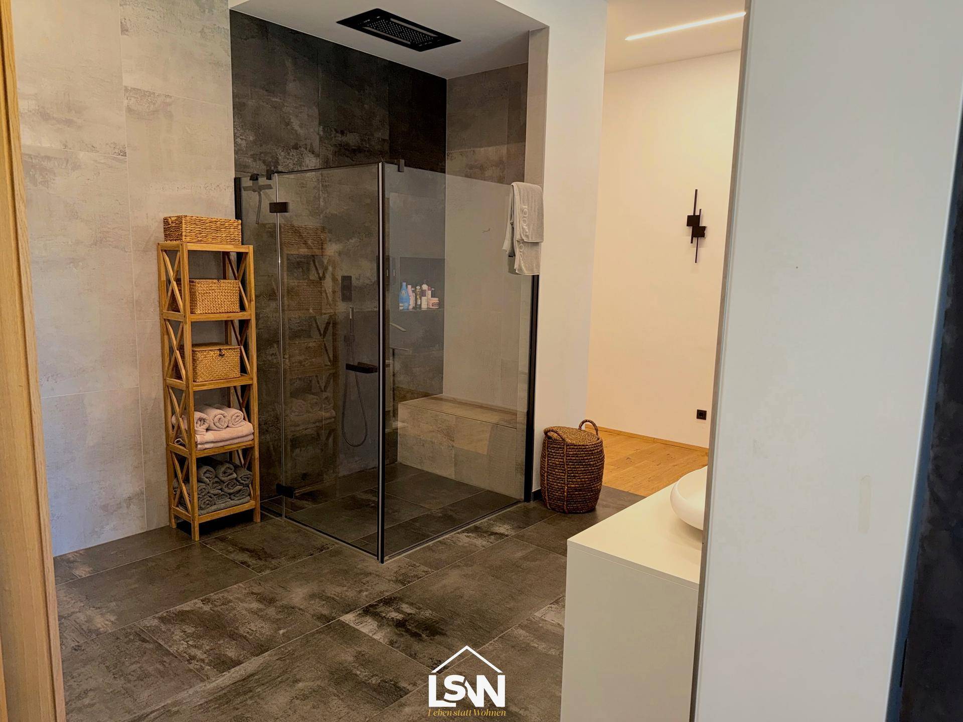 Modernes Badezimmer mit großer begehbarer Dusche und eleganten Fliesen.