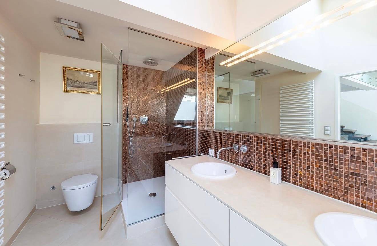 Modernes Badezimmer mit Mosaikfliesen, Doppelwaschbecken und begehbarer Dusche.
