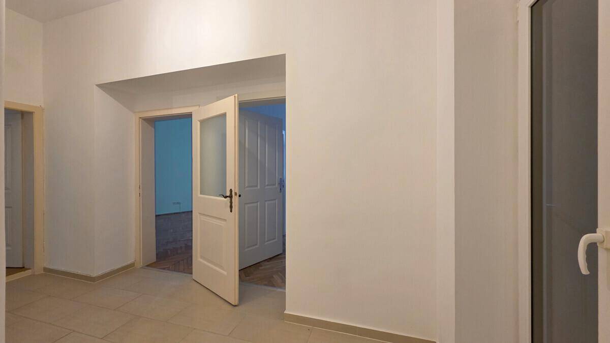 Geräumiger Flur mit hellem Fliesenboden und offenen Türen zu weiteren Zimmern.