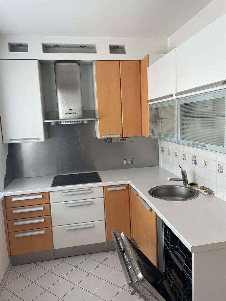 Funktionale Küche mit hellen Schränken, Induktionskochfeld und integriertem Geschirrspüler.