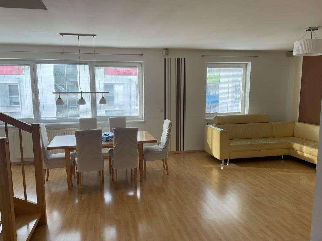 Heller Wohn- und Essbereich mit Esstisch, Sofa und großen Fenstern für viel Tageslicht.