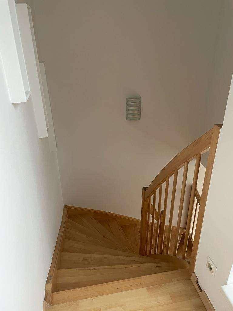 Elegante Holztreppe, die die verschiedenen Wohnebenen miteinander verbindet.