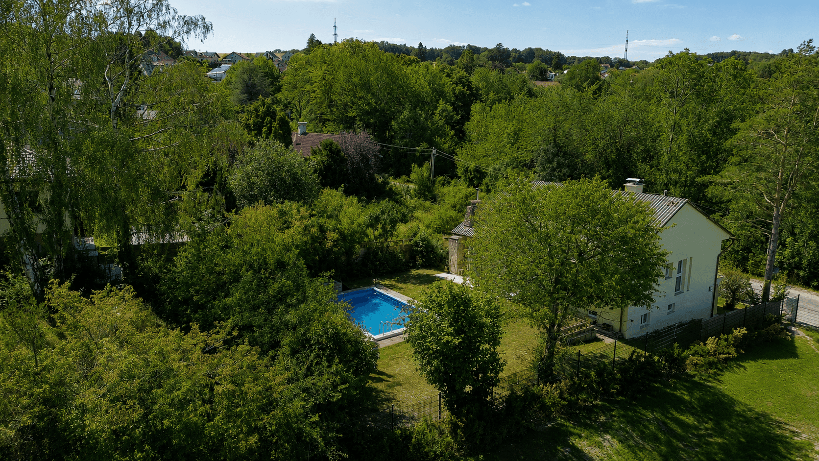 Luftaufnahme des Anwesens mit Haus, Swimmingpool und weitläufiger grüner Umgebung.