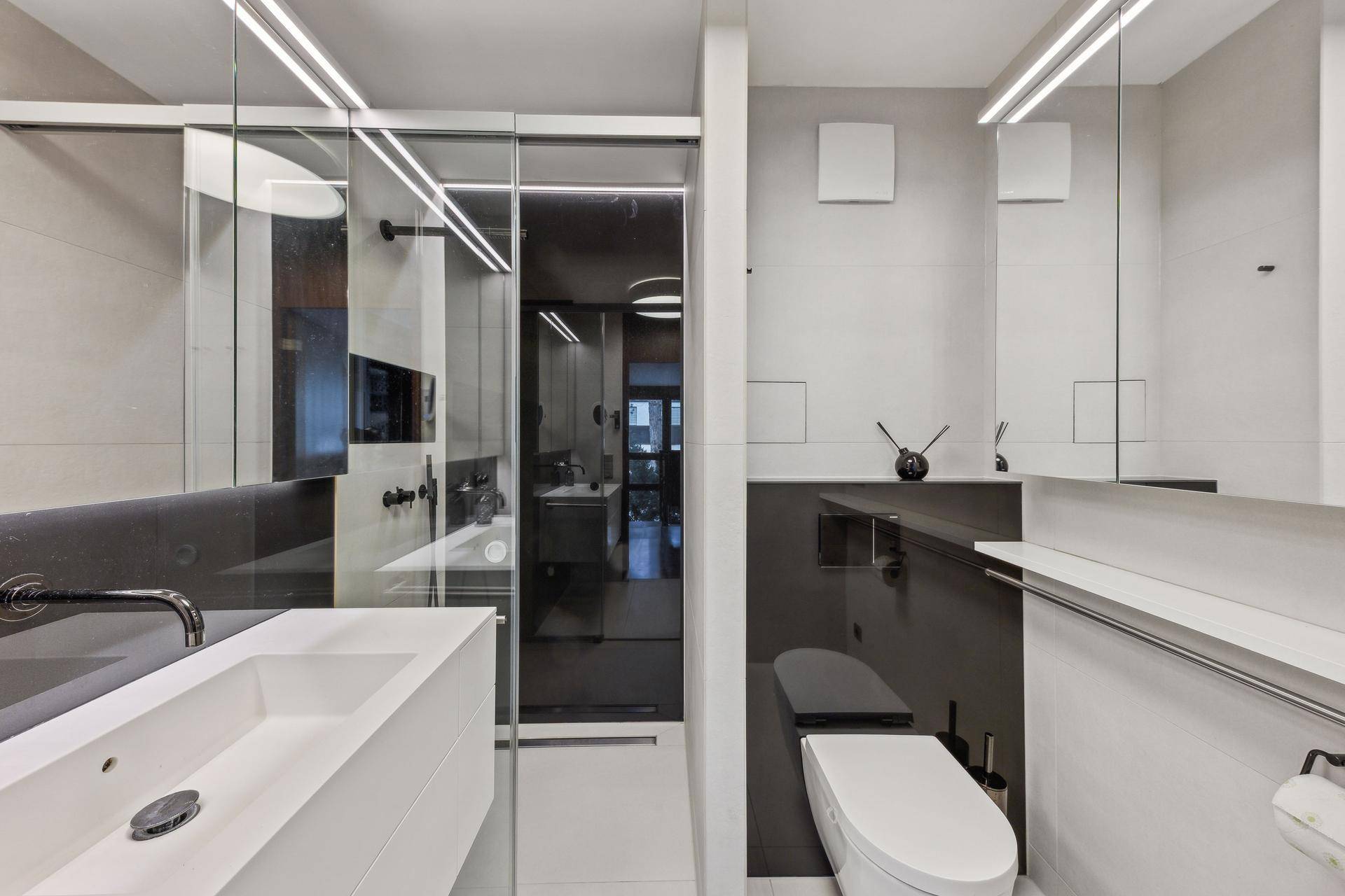 Modernes Badezimmer mit Doppelwaschbecken, begehbarer Dusche und eleganten, großformatigen Fliesen.