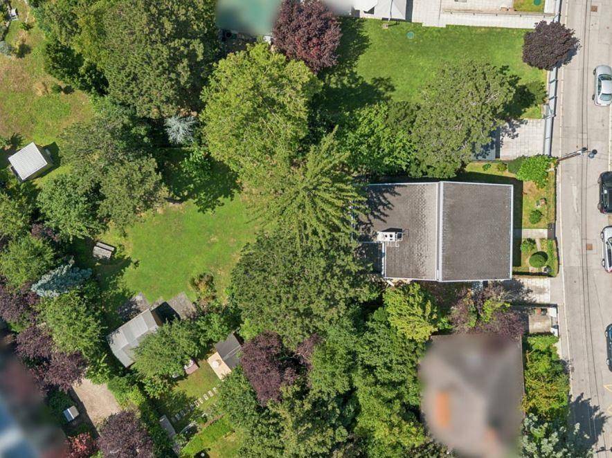 Luftaufnahme des Anwesens mit einem weitläufigen Garten und umgebender grüner Landschaft.