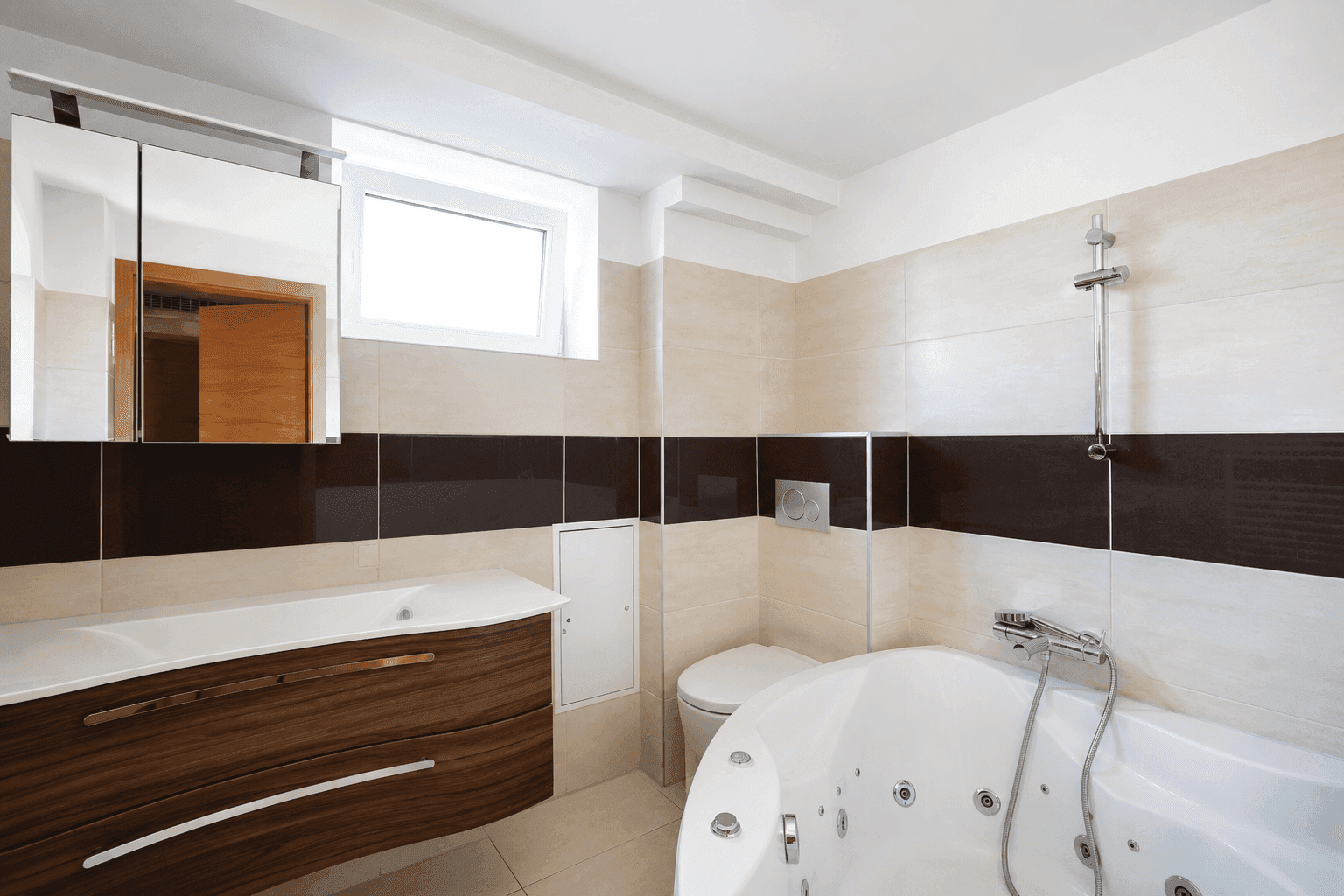 Badezimmer mit Eckbadewanne, modernem Waschtisch, Toilette und Fenster.