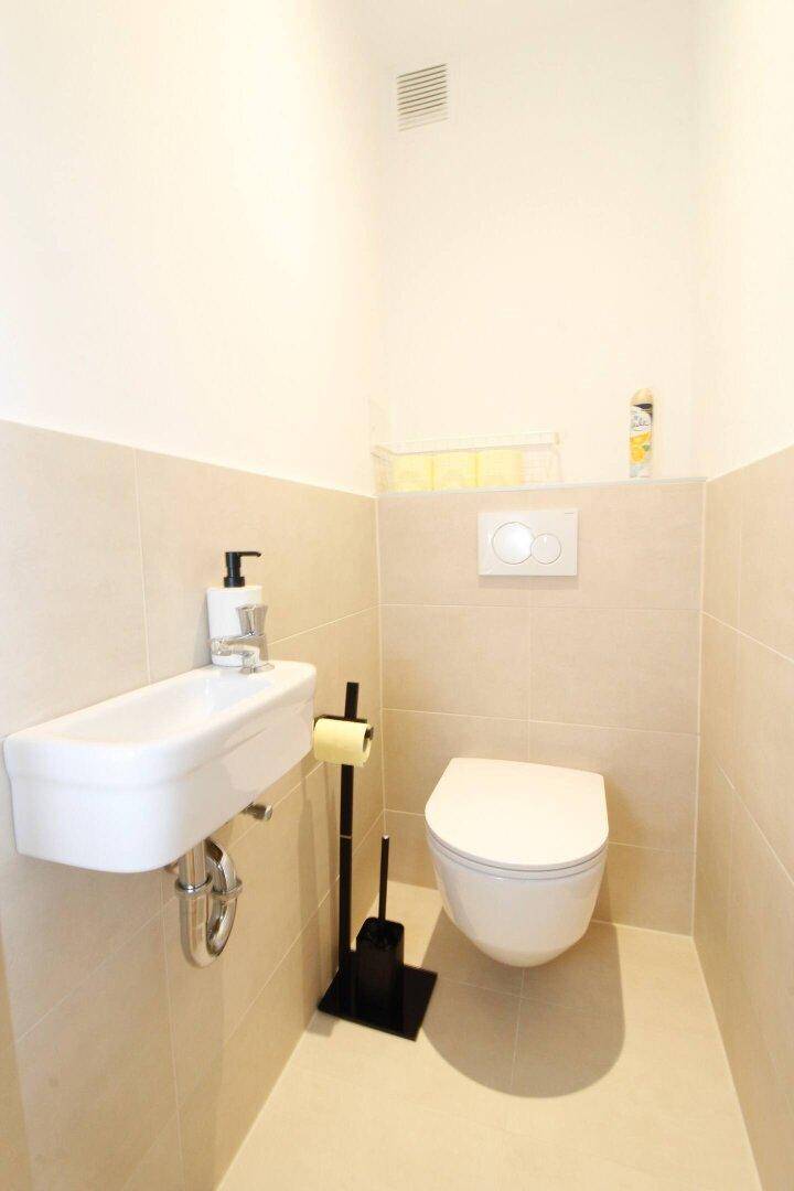 Modernes Gäste-WC mit Wand-WC und kleinem Waschbecken.