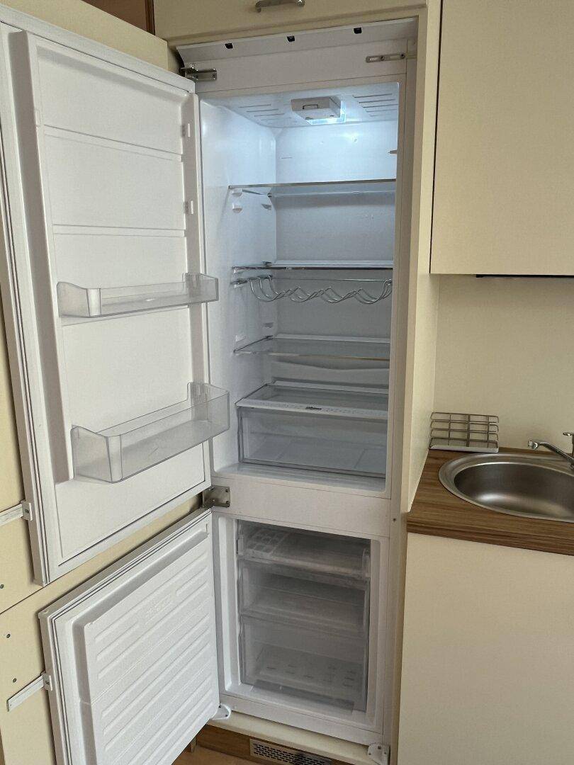 Integrierter Kühlschrank mit Gefrierfach in der modernen Einbauküche.