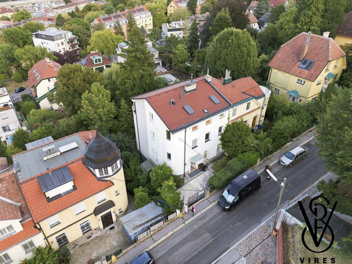 Luftaufnahme eines Wohnviertels mit Häusern, Straßen und viel Grün.