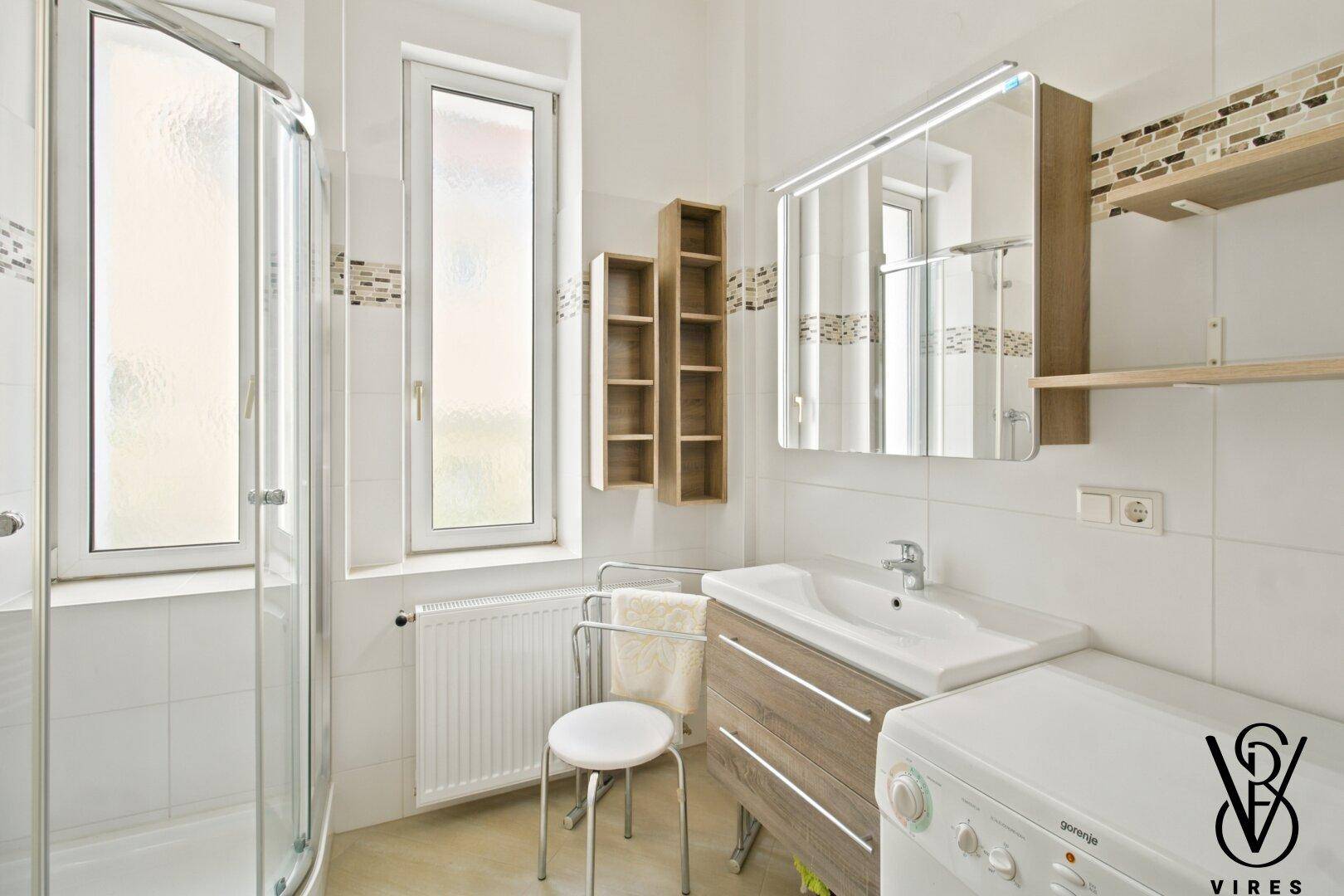 Modernes Badezimmer mit Dusche, Waschbecken und Fenster.