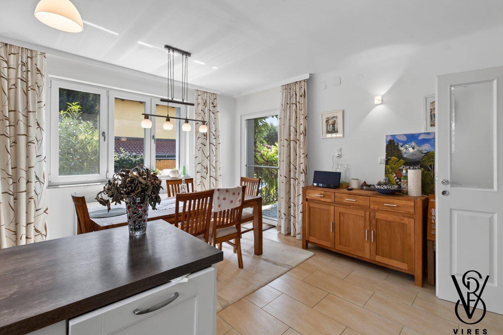 Helle Wohnküche mit Essbereich, Holzmöbeln und Terrassenzugang, ideal für gesellige Runden.