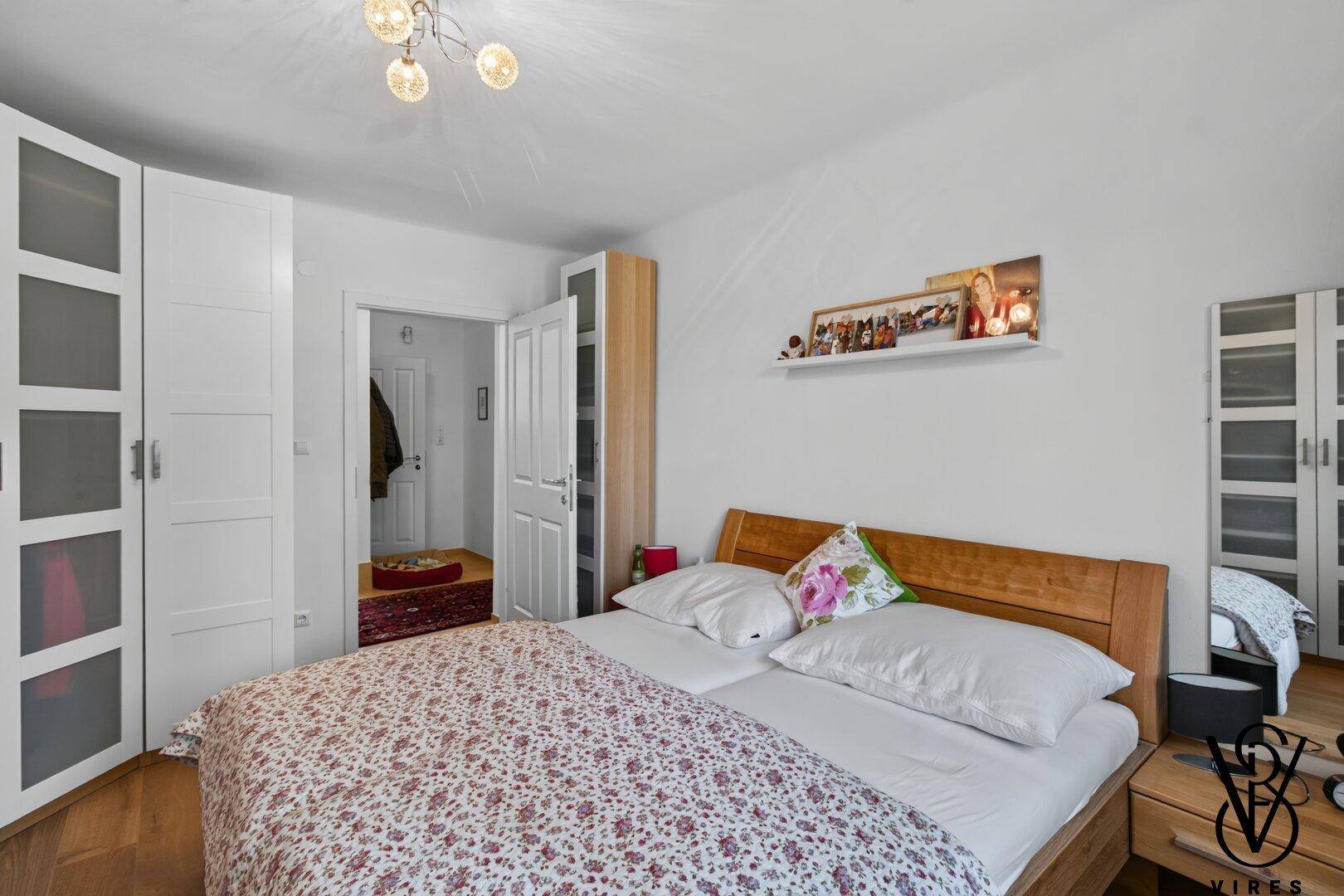 Gemütliches Schlafzimmer mit Holzbett und praktischen Kleiderschränken.