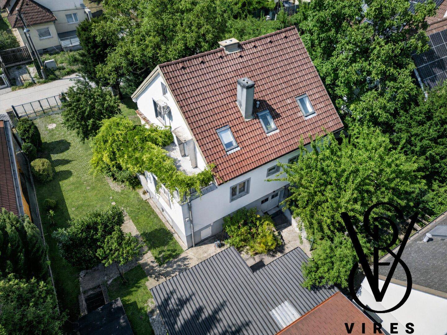 Luftaufnahme des Hauses mit rotem Ziegeldach und grüner Umgebung.
