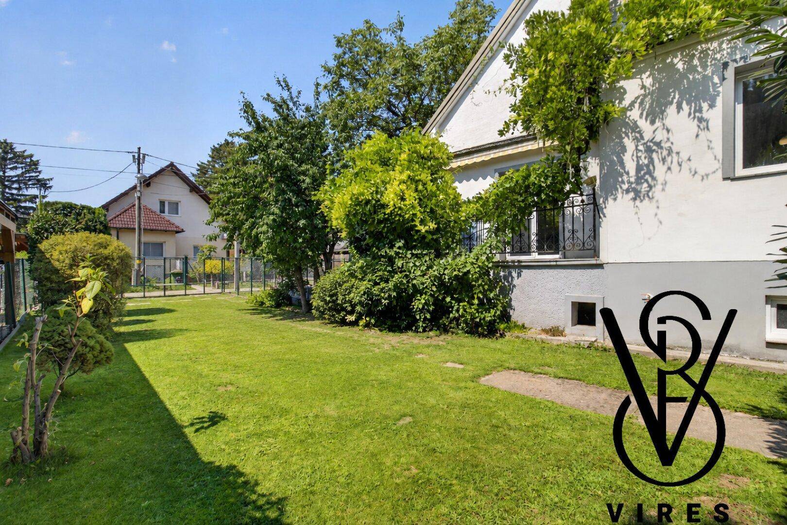 Großer Garten mit weitläufiger Rasenfläche und Blick auf die Hausfassade.
