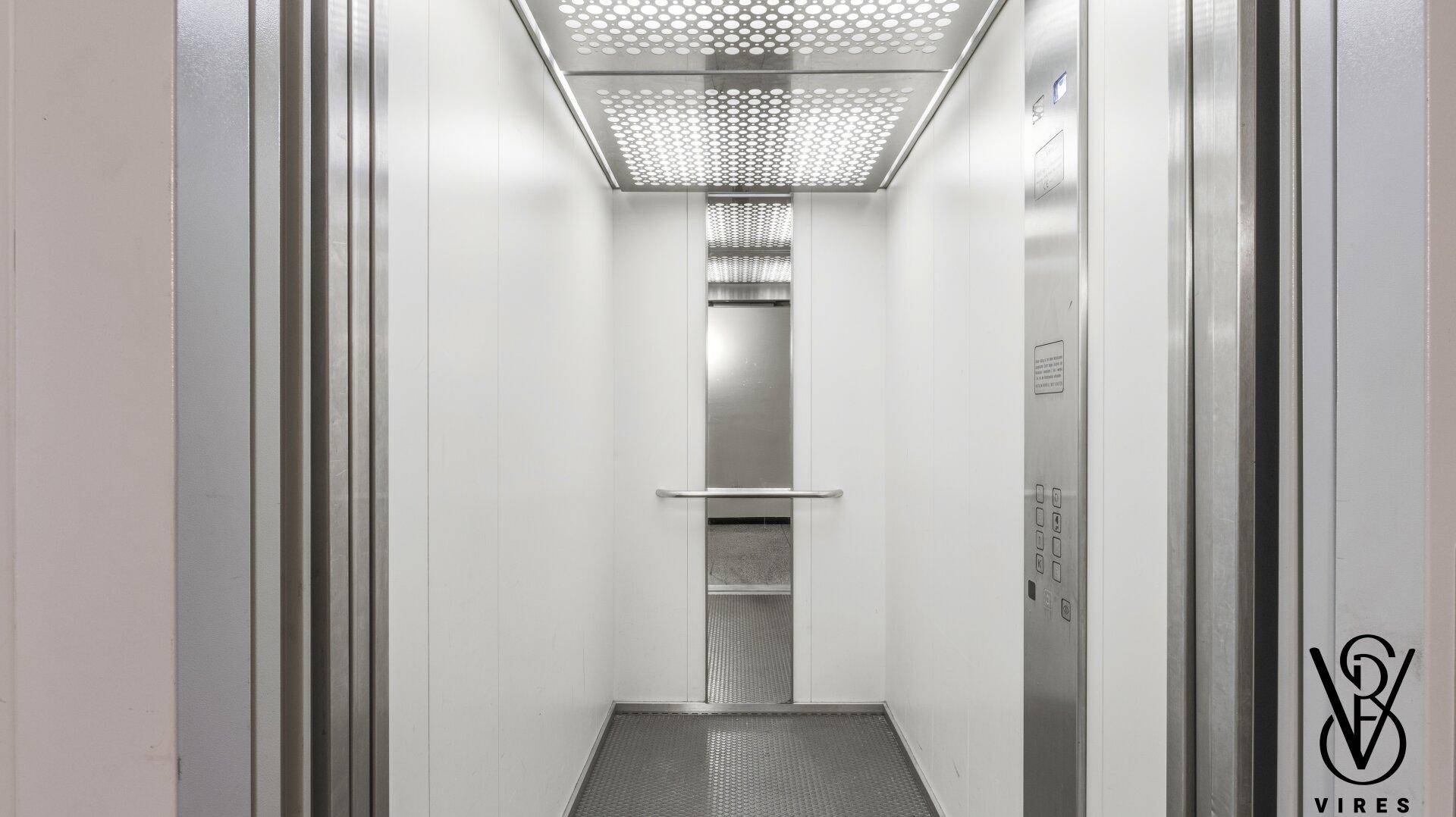 Moderner und sauberer Aufzug mit Edelstahlelementen und Spiegelfläche.