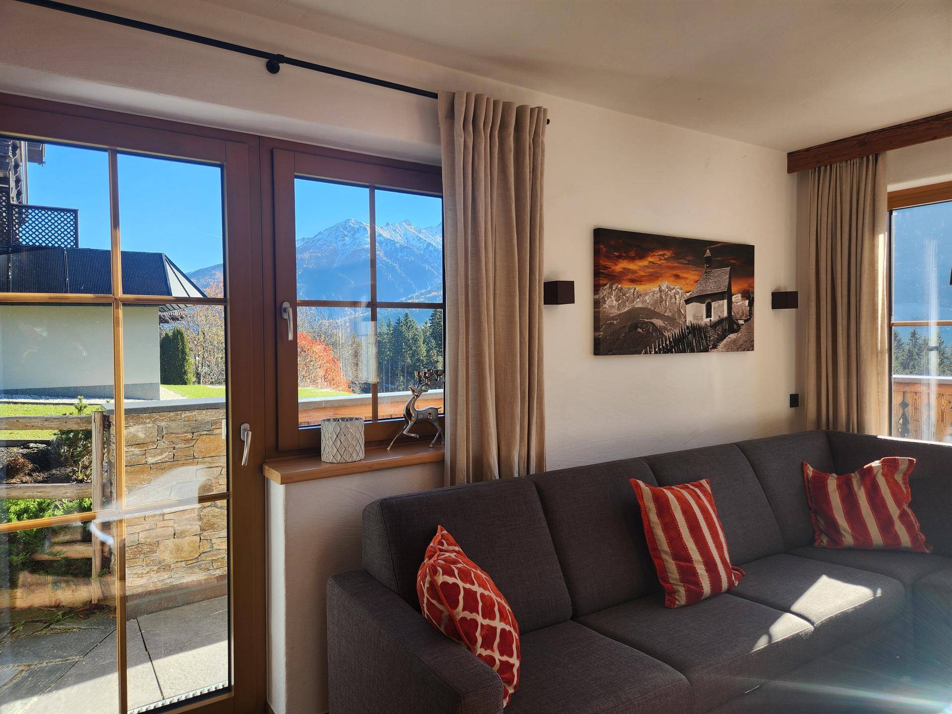 Lichtdurchflutetes Wohnzimmer mit Zugang zur Terrasse und Blick auf die umliegende Natur.