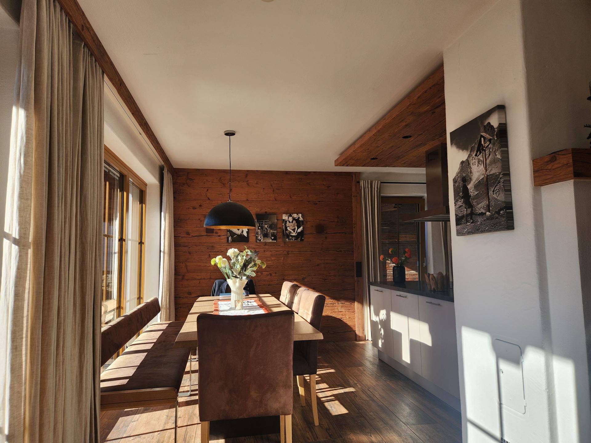 Heller Essbereich mit Holzboden, großem Esstisch und Zugang zur Terrasse.