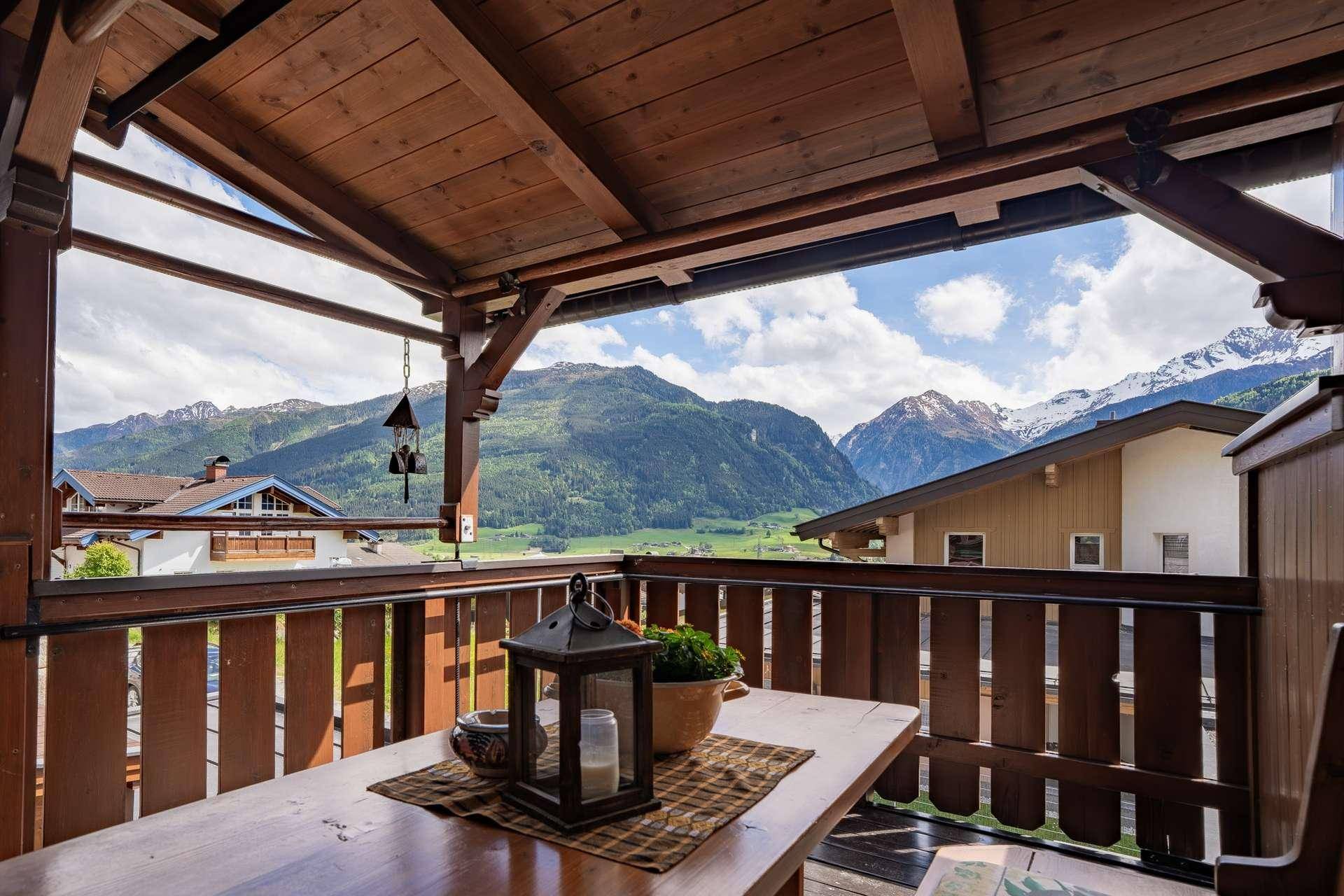 Gemütlicher Holzbalkon mit Bergblick und traditioneller Dekoration.